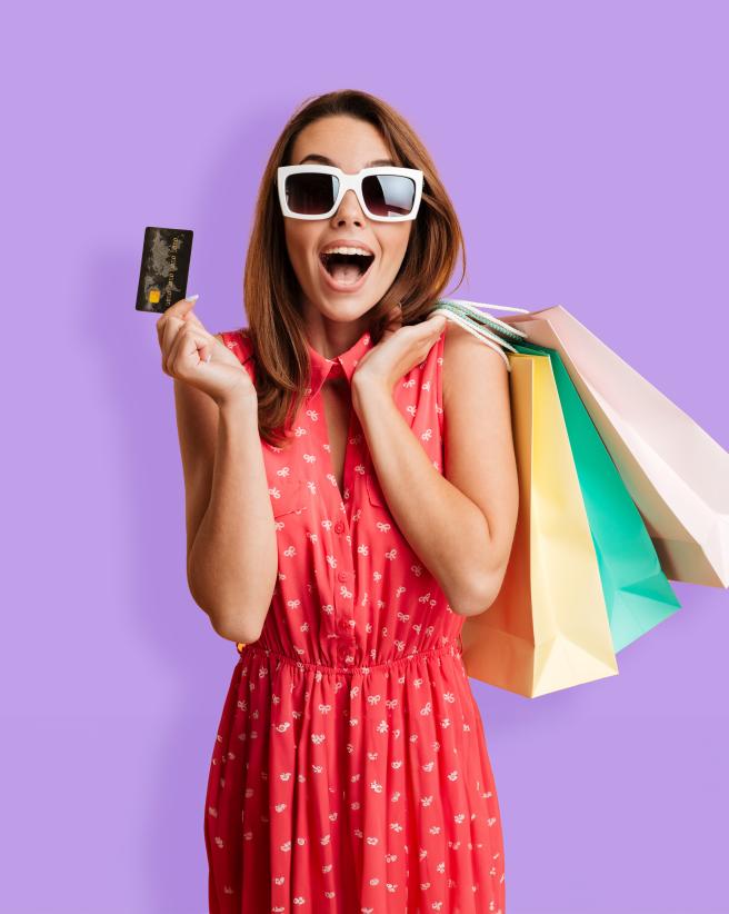 Woman holding credit card and colorful shopping bags.