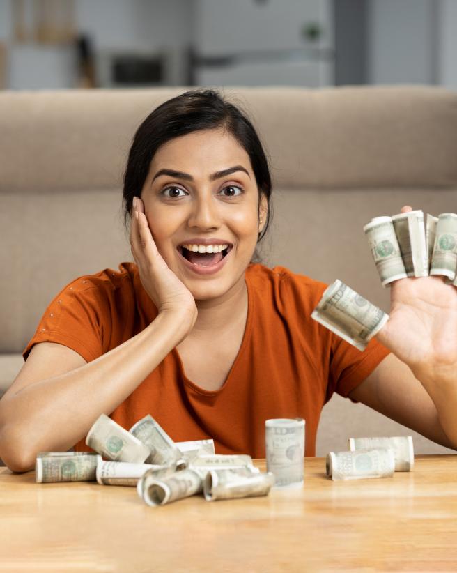 happy woman with US dollars wrapped around fingers