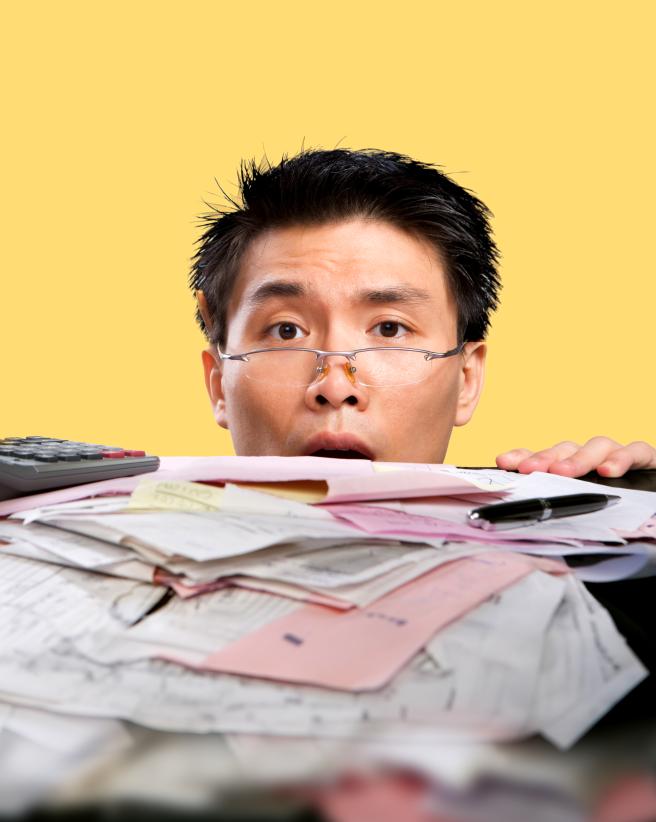Man looking over a stack of documents.