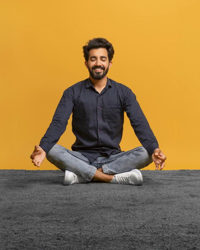 Relaxed young man in casual clothes meditating.