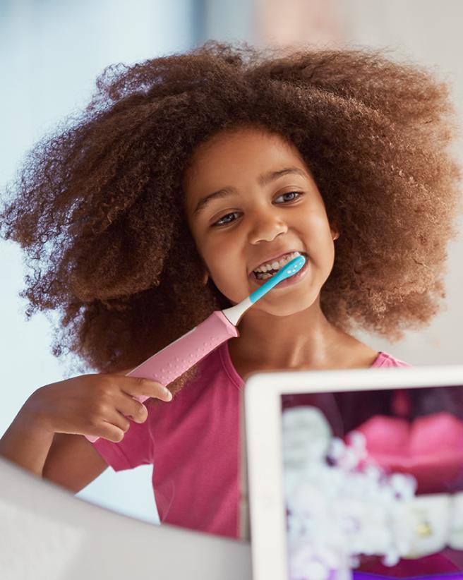 Child brushing teeth with Sonicare toothbrush and app