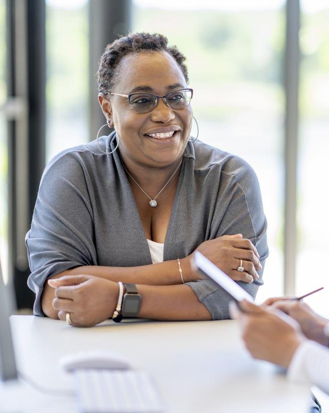 medical professional with paperwork looking at smiling woman