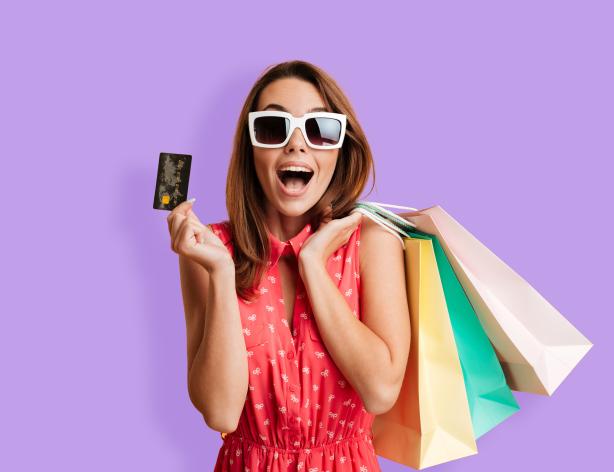 Woman holding credit card and colorful shopping bags.
