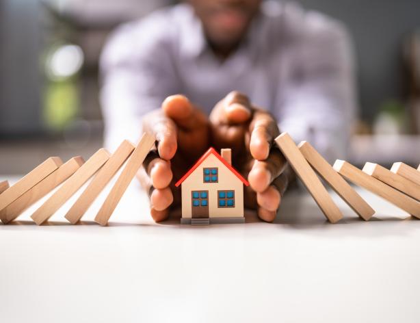 Hands protecting a home.