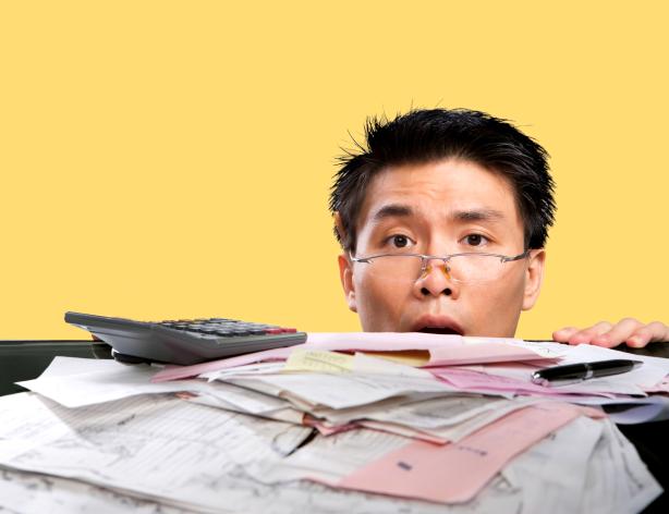 Man looking over a stack of documents.