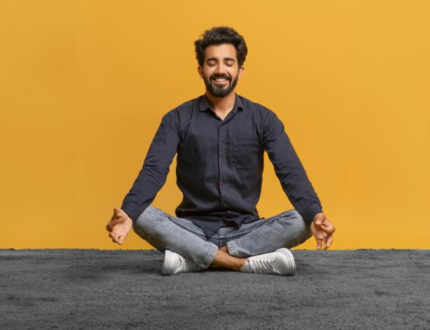 Relaxed young man in casual clothes meditating.