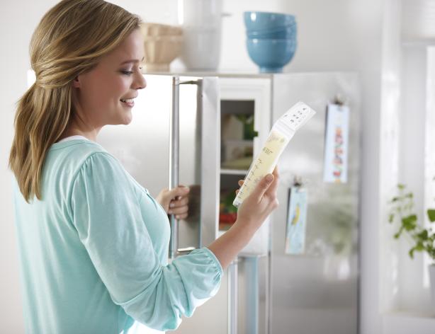 woman putting bag of breastmilk in freezer