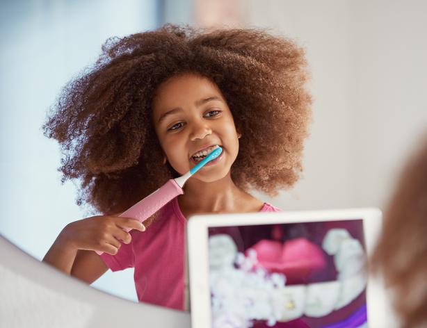 Child brushing teeth with Sonicare toothbrush and app
