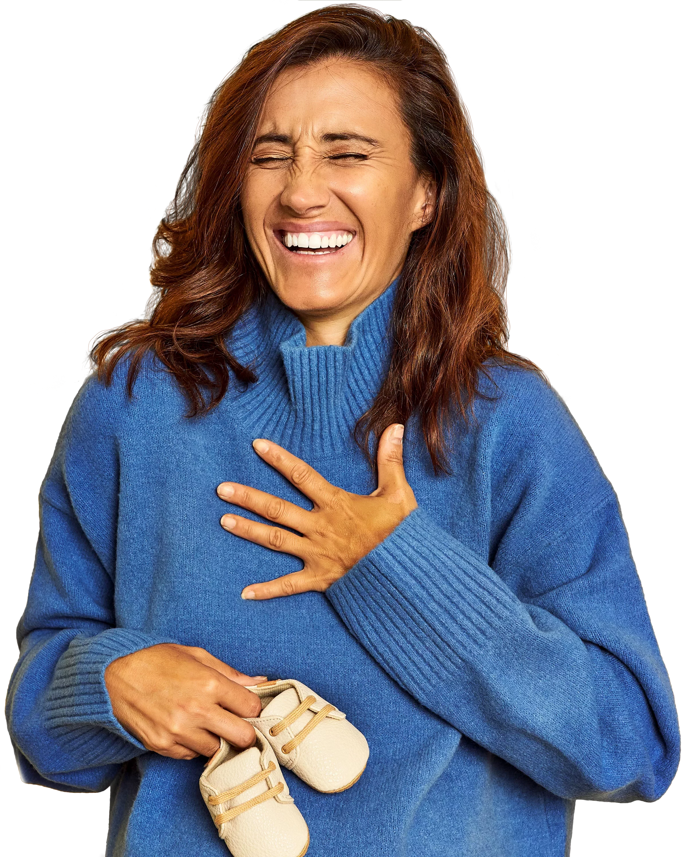 Happy woman smiling broadly. She is holding baby shoes.